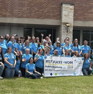 Peterson Health staff holding a banner outside, celebrating workplace recognition in healthcare.