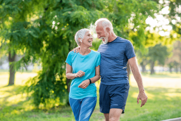 older woman with older man exercising in park